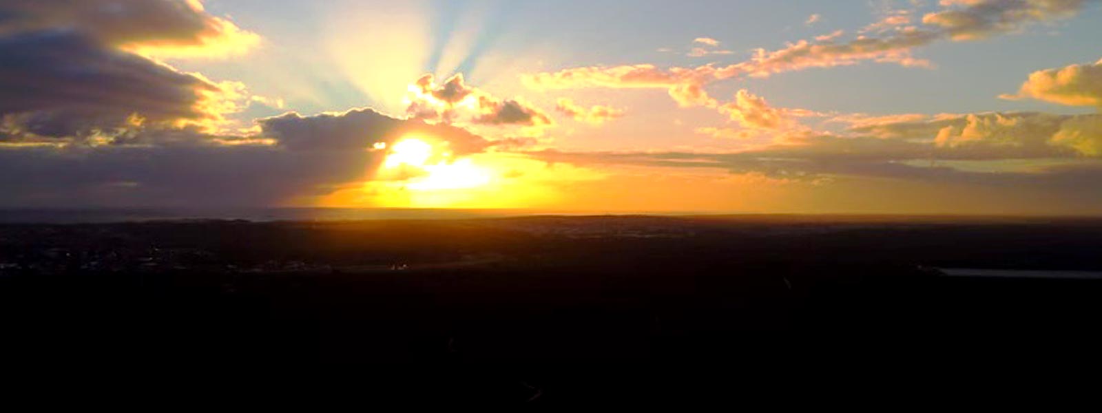 Beautiful Sunset with rays of sun peaking out behind clouds