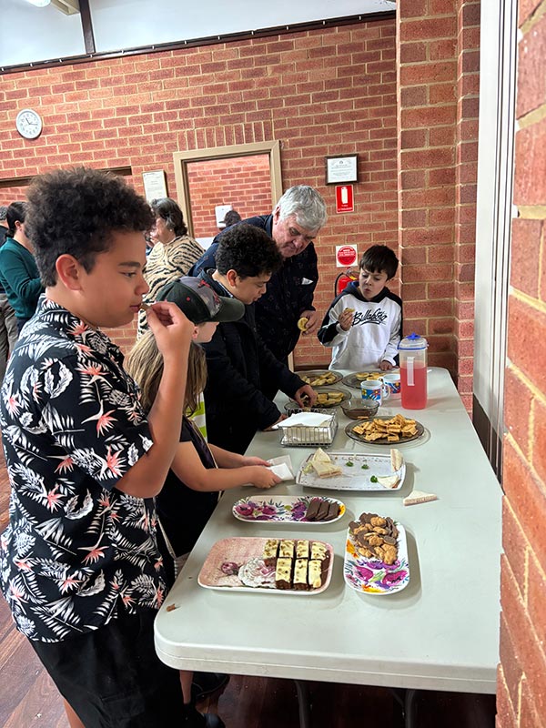Children with Elder tasting snacks during morning tea after services at Providence Reformed Baptist Church