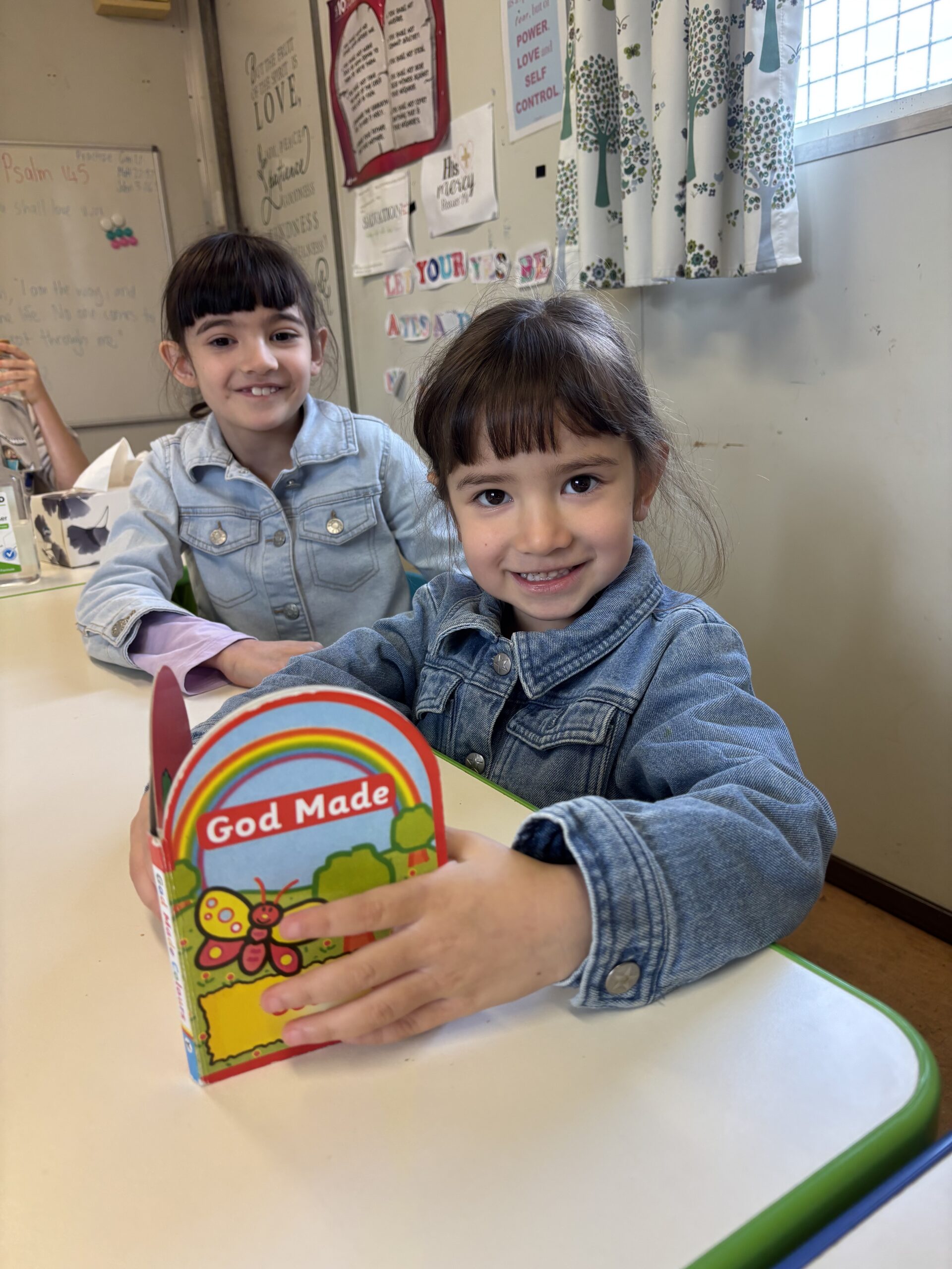 Closeup of two small girls at Providence Reformed Baptist Church reading religious learning book