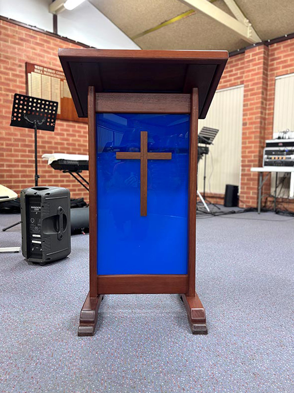 Baptist church lectern with wooden cross on a blue background